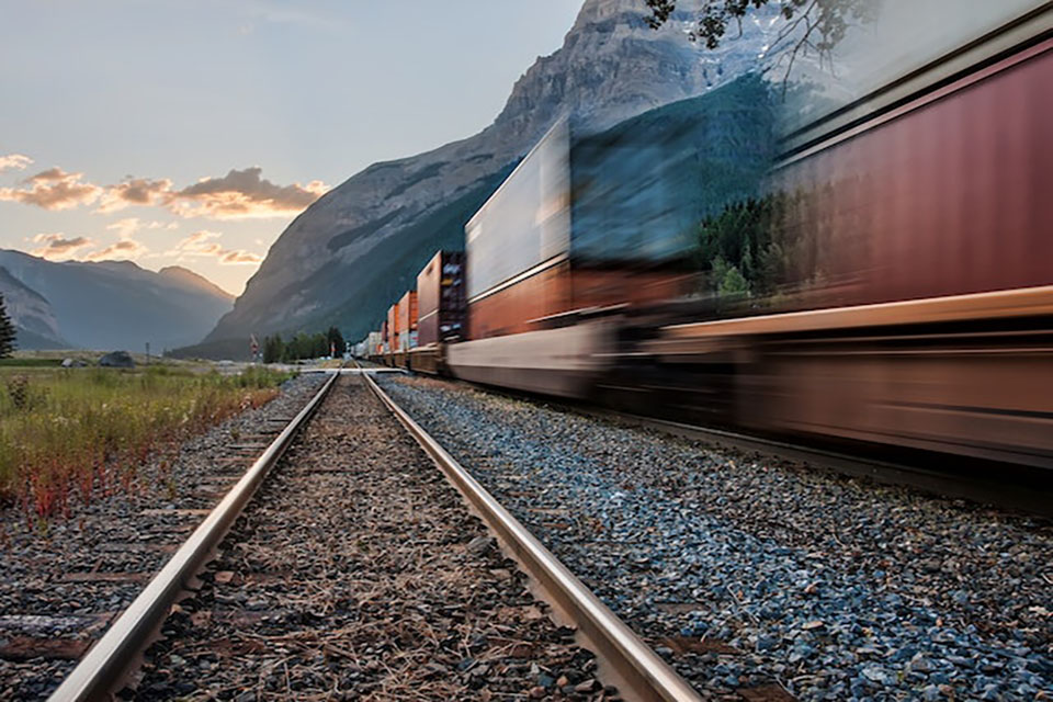 High speed train going through valley of mountains.