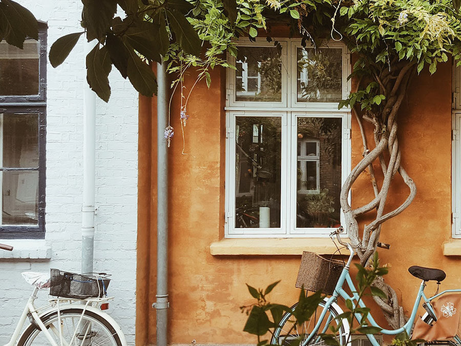 A bright family home with two bicycles parked at the front door.