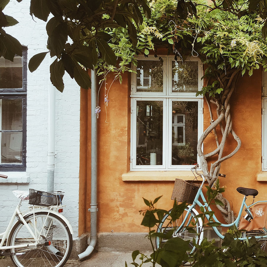 A bright family home with two bicycles parked at the front door.